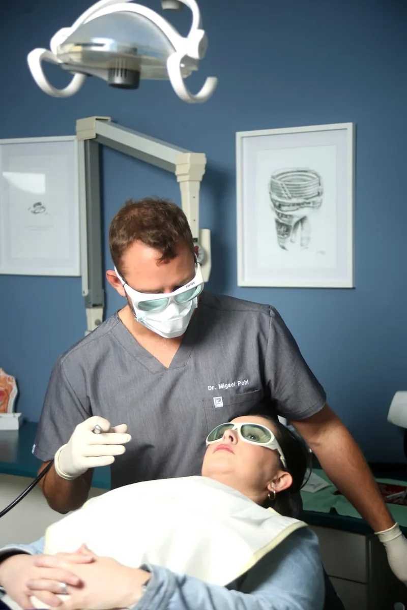 Dr Migael Pohl performing a laser dentistry procedure, with both clinician and patient wearing protective eyewear